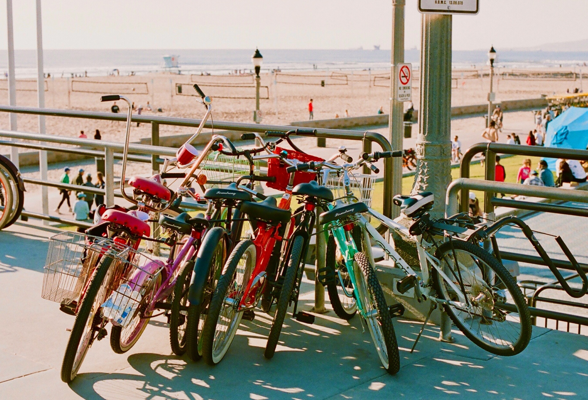 Beach cruiser bikes lined up along the Huntington Beach boardwalk