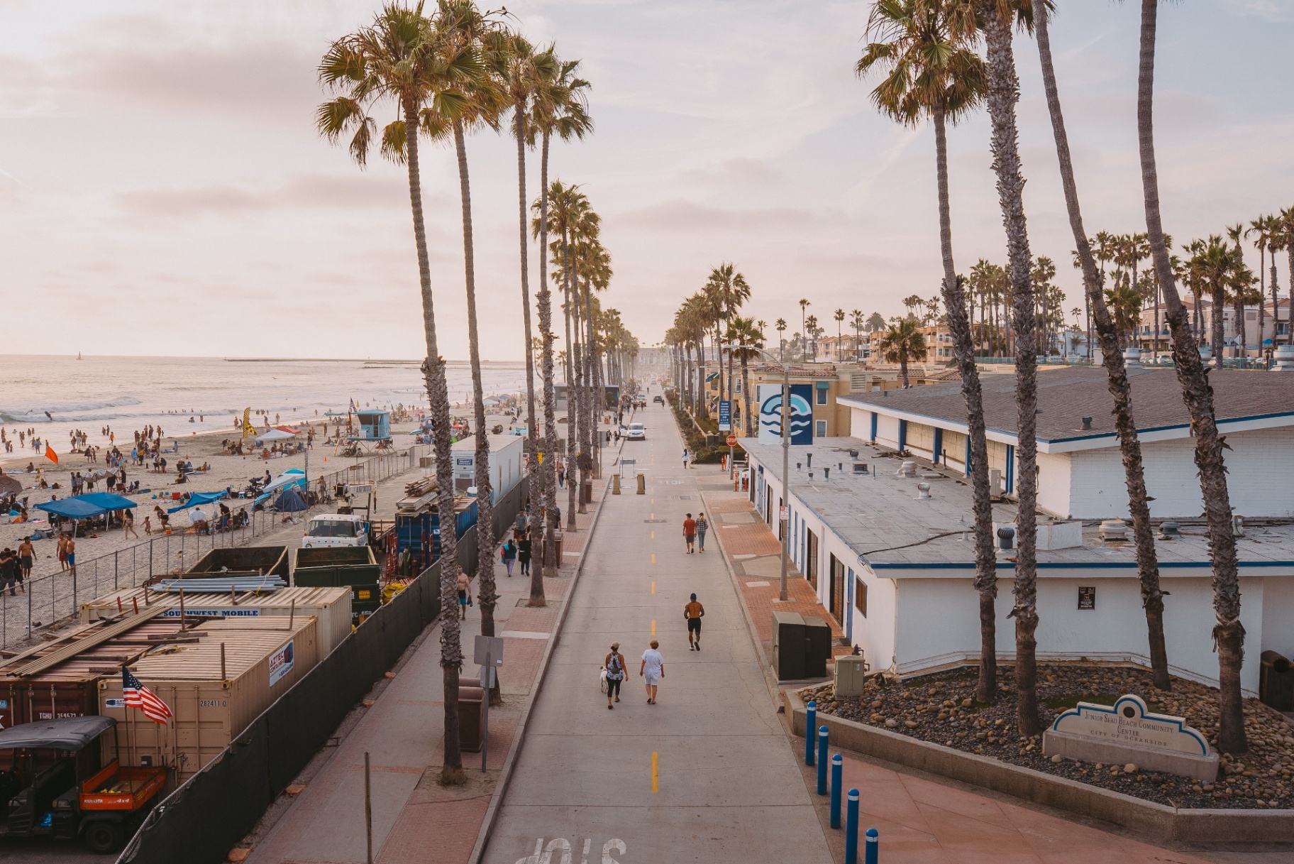 Palm-lined boardwalk near the Huntington Beach shore at sunset