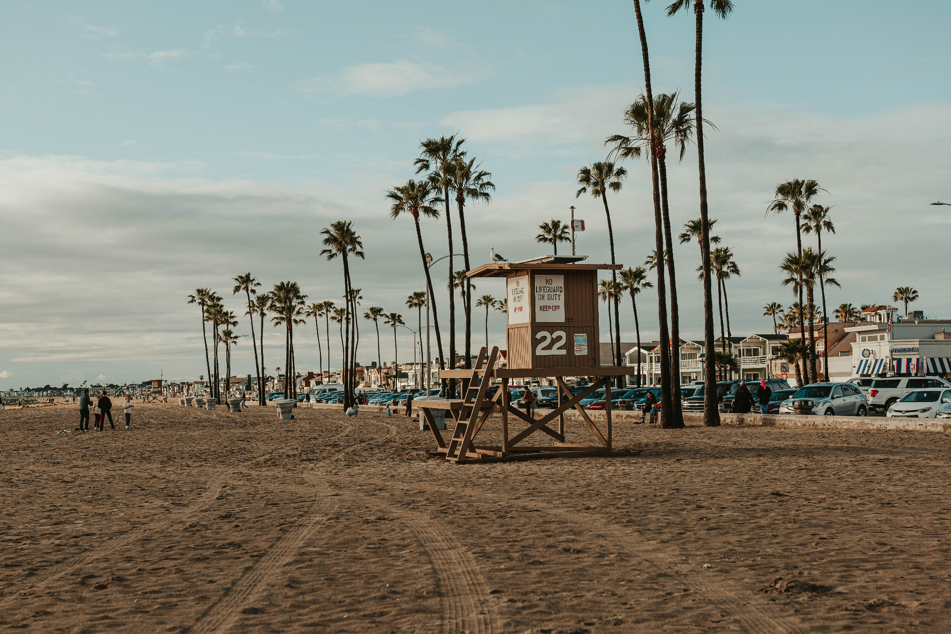 Huntington Beach palm-lined boardwalk with lifeguard tower